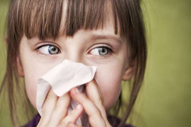 Girl with tissue, blowing her nose