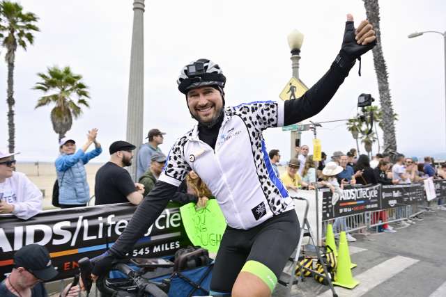 Thomas Johansen waves to the crowd at the Santa Monica Pier, at the end of the 2024 AIDS/Lifecycle ride