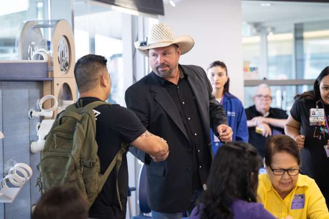 Garth Brooks greets a fan during his visit to the Child Life Zone at UCLA Mattel Children's Hospital