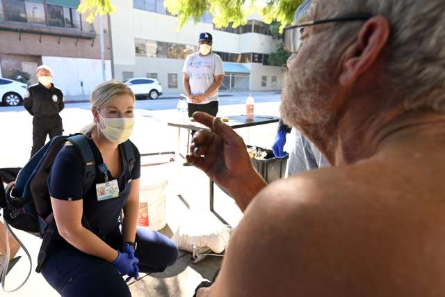 Nurse Zoe McFall visits with patient Jon Blasingame during her rotation with the Homeless Healthcare Collaborative