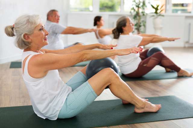 An older woman participates in a Pilates class