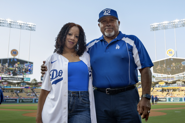 UCLA Health nurse Lakeysha Pack with Rudy Lopez, the umpire whose life she saved using CPR, pose together on the field at Dodger Stadium.