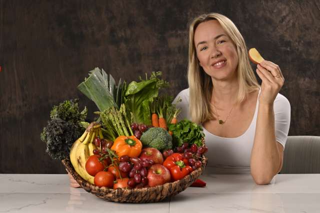 Emma Veilleux shows a basket of healthy fruits and vegetables