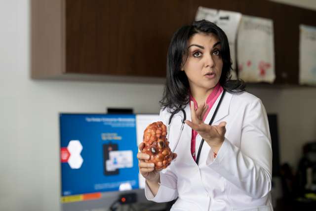Dr. Niloofar Nobakht holds a small model of a diseased kidney, in her office.
