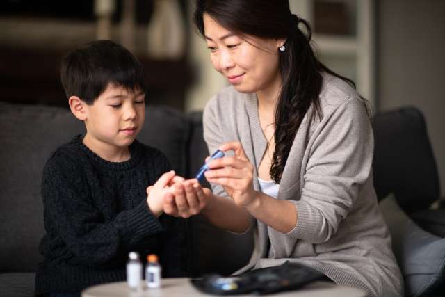 Mother checking child's blood sugar