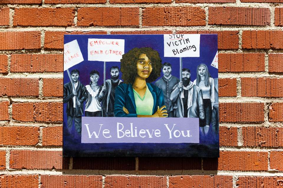 Mural on brick wall of woman and protesters