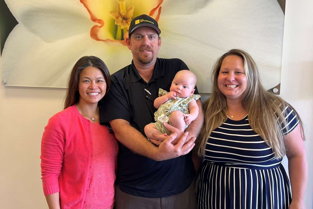 Dr. Deborah Wong poses with Jeff and Rachel Goar and their baby daughter.