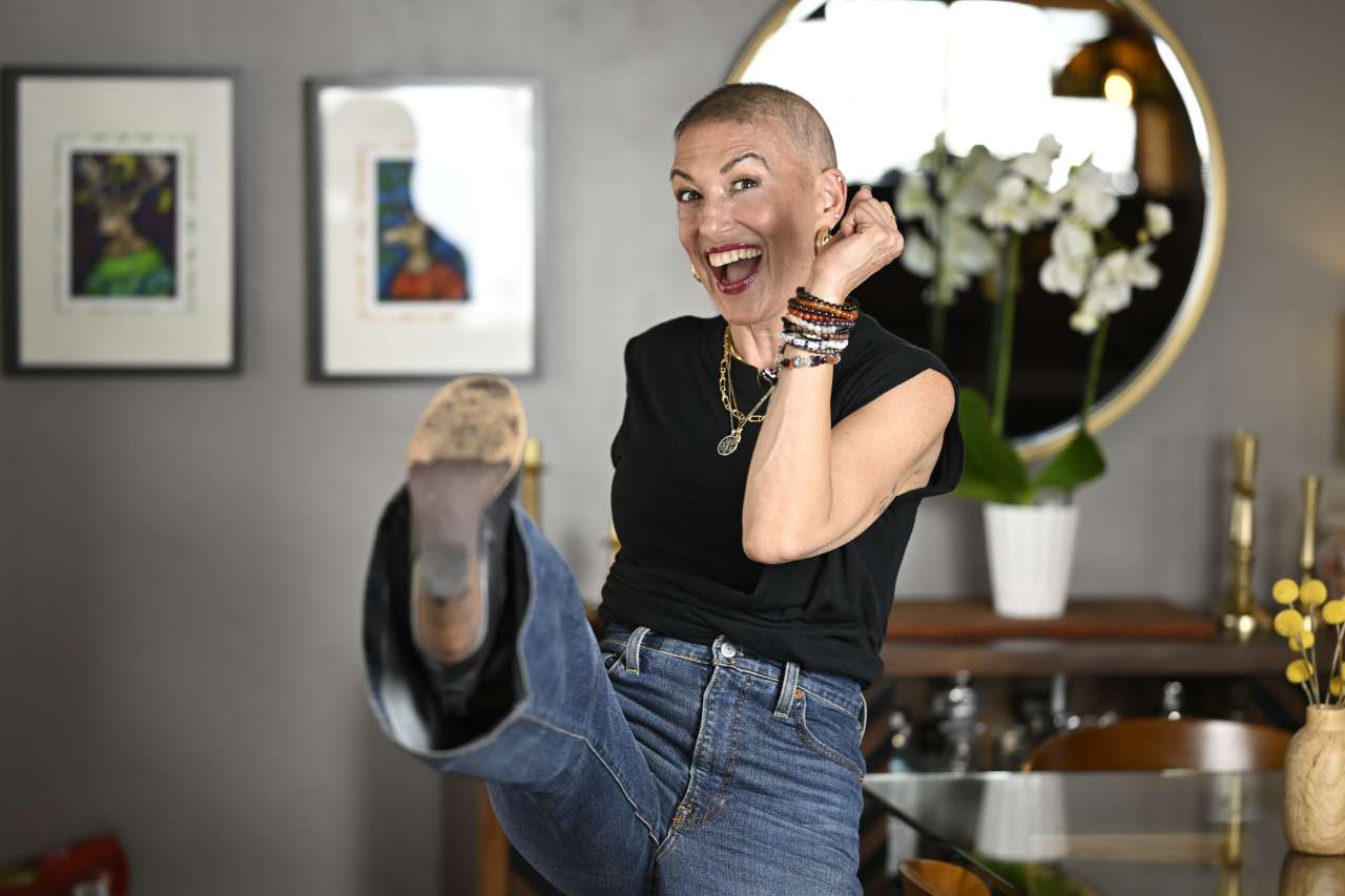 Ali Spuck playfully kicks her right leg in the air, during a photo session at her home