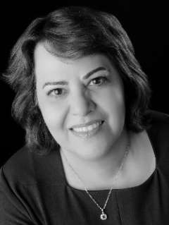 In black and white, Dr. Rana Movahedi, MD, FASA poses for a headshot at an angle with her head tilted slightly to the left.  