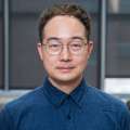 Headshot of Doctor Young Do Koo in a blue button-down shirt and wearing glasses