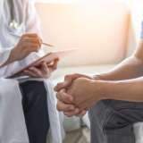 Men's health exam with doctor or psychiatrist working with patient having consultation on diagnostic examination on male disease or mental illness in medical clinic or hospital mental health service