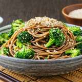 Garlic Sesame Soba Noodles on a bamboo placemat in a grey bowl